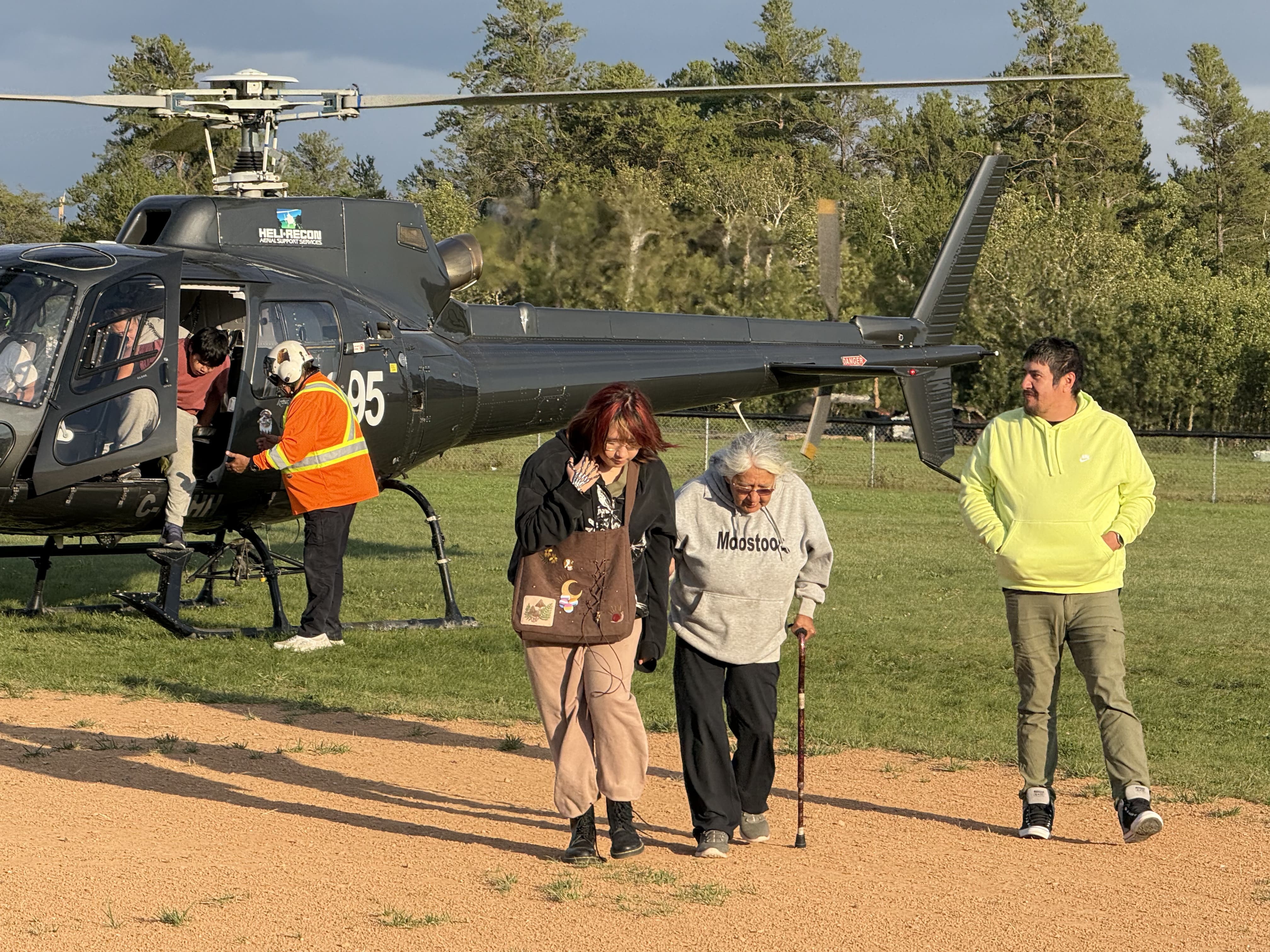 a family getting out of the helicopter, sombody is helping grandma in the foreground